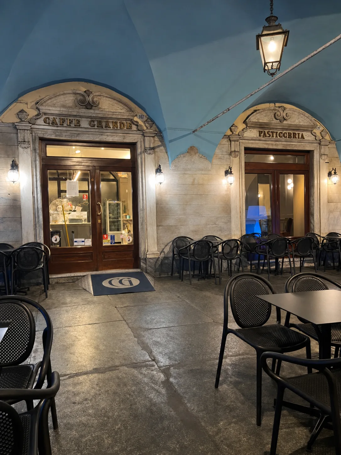 L'ingresso e i tavoli esterni del Caffè Grande illuminati la sera