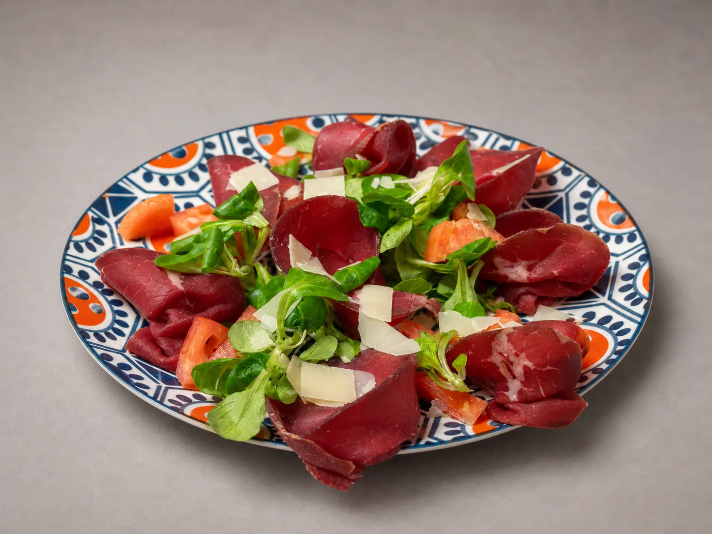 Bresaola con insalata, pomodoro e scaglie di formaggio